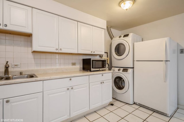 238 W 31st St Unit 2W, Chicago, IL 60616 - washroom with estacked washer and dryer and light tile patterned flooring