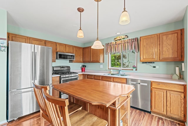 7 Farmington Ct, Lake In The Hills, IL 60156 - kitchen featuring appliances with stainless steel finishes, a sink, light countertops, and pendant lighting