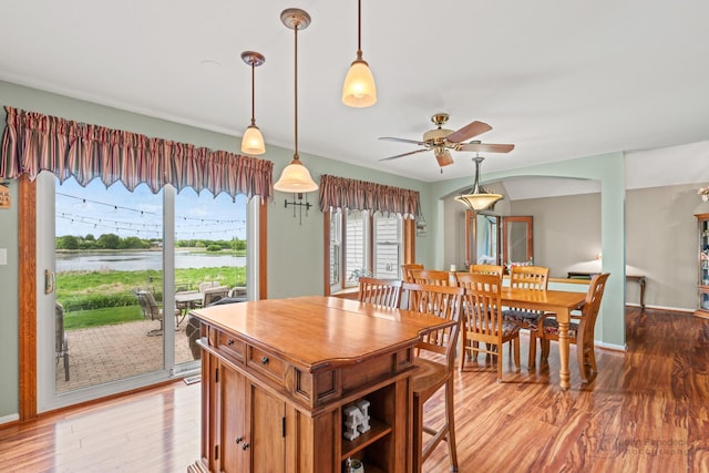7 Farmington Ct, Lake In The Hills, IL 60156 - dining area with light wood-style flooring, a ceiling fan, a water view, and baseboards