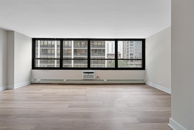 33 E Cedar St Unit 6B, Chicago, IL 60611 - empty room featuring wood finished floors, baseboards, and a wall mounted air conditioner