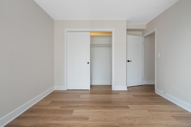33 E Cedar St Unit 6B, Chicago, IL 60611 - unfurnished bedroom featuring light wood-style floors, a closet, and baseboards