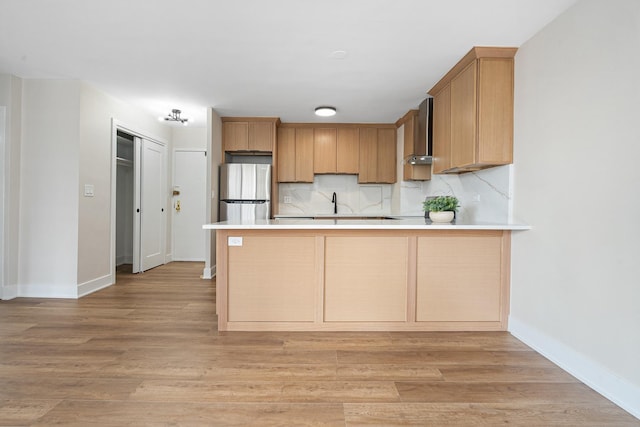33 E Cedar St Unit 6B, Chicago, IL 60611 - kitchen with freestanding refrigerator, wall chimney exhaust hood, a peninsula, and decorative backsplash