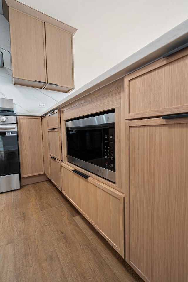 33 E Cedar St Unit 6B, Chicago, IL 60611 - kitchen with light brown cabinetry, stainless steel appliances, wood finished floors, and light countertops