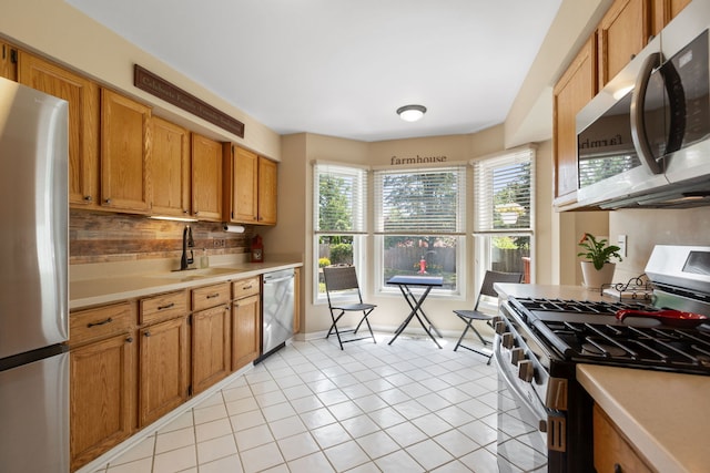 211 Spring Point Dr, Carpentersville, IL 60110 - kitchen featuring stainless steel appliances, light countertops, tasteful backsplash, light tile patterned floors, and brown cabinets