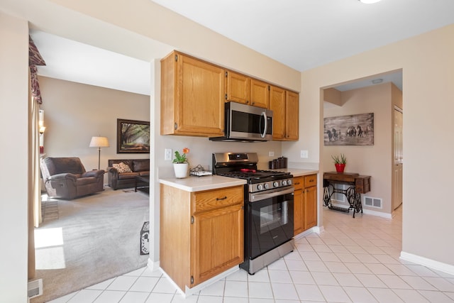 211 Spring Point Dr, Carpentersville, IL 60110 - kitchen with stainless steel appliances, light countertops, light tile patterned flooring, open floor plan, and light colored carpet