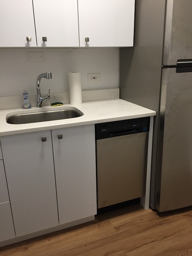 3600 N Lake Shore Dr Unit 1603, Chicago, IL 60613 - kitchen with dishwasher, a sink, light countertops, light wood finished floors, and white cabinetry