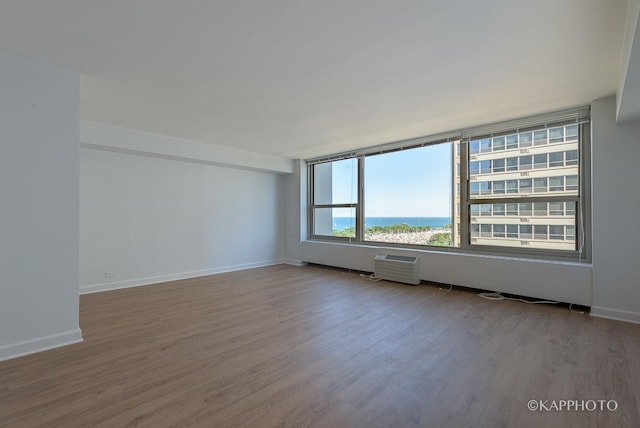 3600 N Lake Shore Dr Unit 1603, Chicago, IL 60613 - spare room with wood finished floors, a wall unit AC, baseboards, and a water view
