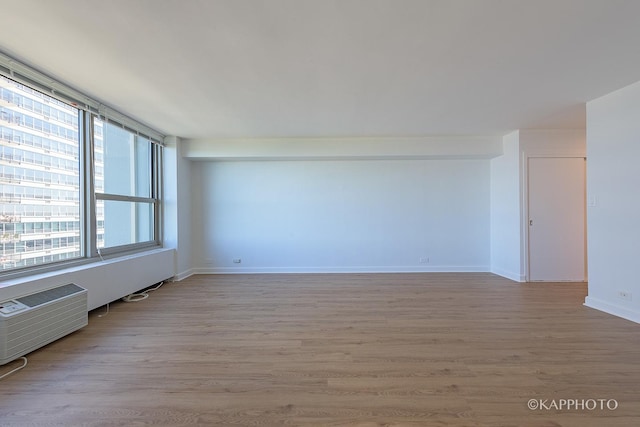 3600 N Lake Shore Dr Unit 1603, Chicago, IL 60613 - spare room with light wood-style flooring, a wall unit AC, and baseboards