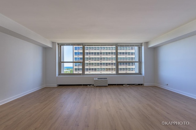 3600 N Lake Shore Dr Unit 1603, Chicago, IL 60613 - empty room featuring wood finished floors, baseboards, and a wall mounted air conditioner
