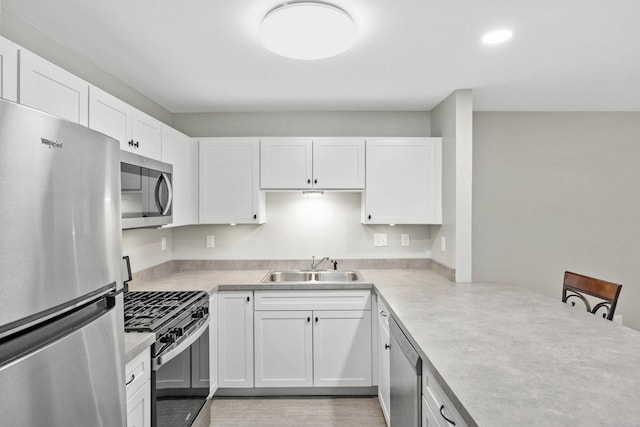 9810 Parkway Dr None, Unit None, Highland, IN 46322 - kitchen with stainless steel appliances, a sink, white cabinets, light countertops, and recessed lighting