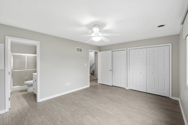 9810 Parkway Dr None, Unit None, Highland, IN 46322 - unfurnished bedroom with multiple closets, light wood-type flooring, baseboards, ensuite bathroom, and a ceiling fan
