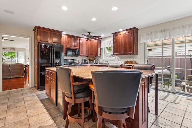 2910 Greystone Pl, Champaign, IL 61822 - kitchen featuring black appliances, ceiling fan, a center island, recessed lighting, and light stone countertops