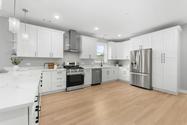 4113 Eberly Ave, Brookfield, IL 60513 - kitchen featuring appliances with stainless steel finishes, wall chimney range hood, white cabinets, light wood finished floors, and a sink