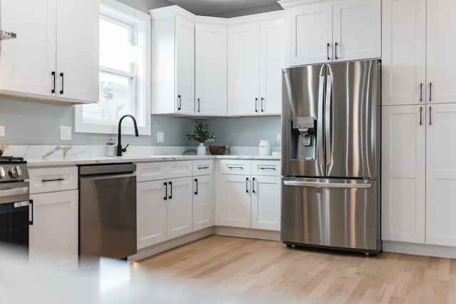 4113 Eberly Ave, Brookfield, IL 60513 - kitchen with appliances with stainless steel finishes, a sink, white cabinets, and light wood-style floors