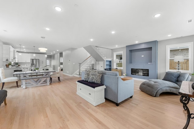 4113 Eberly Ave, Brookfield, IL 60513 - living area featuring stairs, light wood finished floors, baseboards, recessed lighting, and a large fireplace