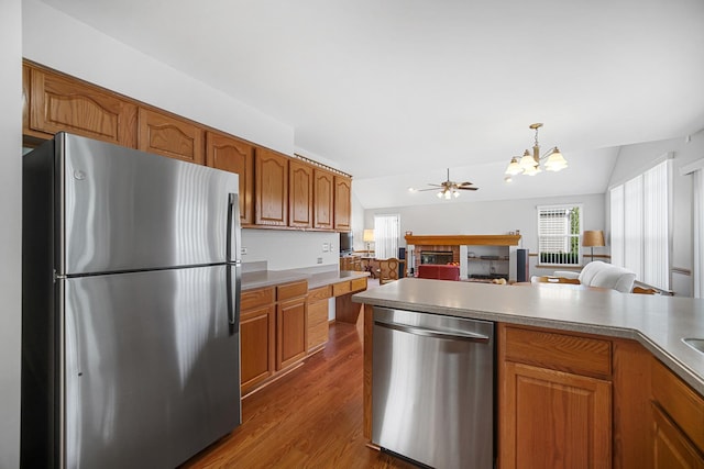 2802 Forestview Dr, Carpentersville, IL 60110 - kitchen with stainless steel appliances, a chandelier, brown cabinetry, dark wood finished floors, and open floor plan