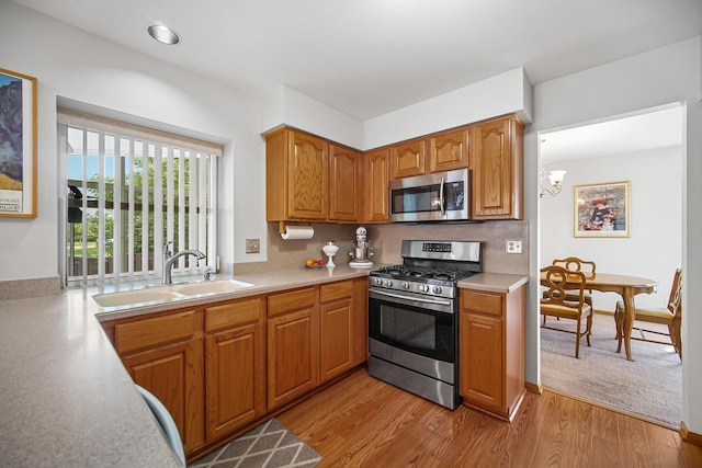 2802 Forestview Dr, Carpentersville, IL 60110 - kitchen with stainless steel appliances, a sink, light countertops, and brown cabinets