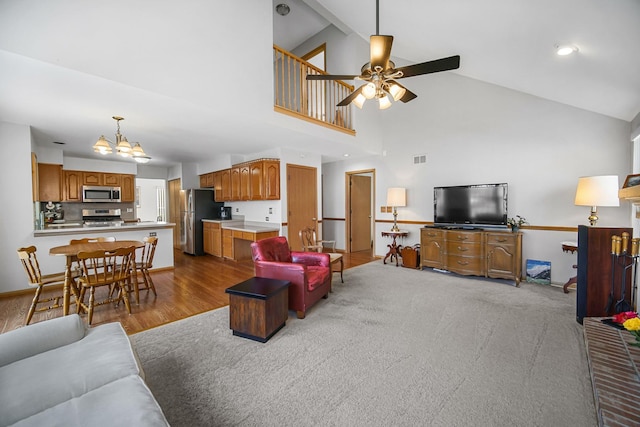 2802 Forestview Dr, Carpentersville, IL 60110 - living room featuring ceiling fan, a chandelier, high vaulted ceiling, baseboards, and wood finished floors