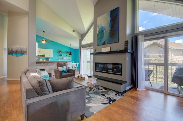 14121 Norwich Ln Unit 301, Orland Park, IL 60467 - living area with healthy amount of natural light, high vaulted ceiling, wood finished floors, a glass covered fireplace, and ceiling fan
