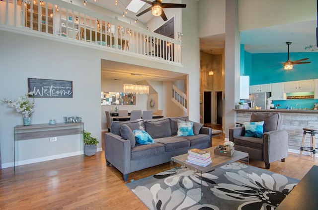 14121 Norwich Ln Unit 301, Orland Park, IL 60467 - living room with ceiling fan, high vaulted ceiling, a chandelier, wood finished floors, and stairs