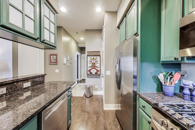 888 S Michigan Ave Unit 601, Chicago, IL 60605 - kitchen with green cabinetry, stainless steel appliances, wood finished floors, recessed lighting, and dark stone counters
