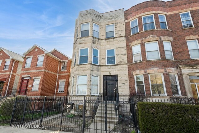 3540 S Prairie Ave Unit 1, Chicago, IL 60653 - multi unit property featuring stone siding and a fenced front yard