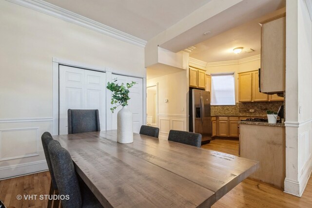 3540 S Prairie Ave Unit 1, Chicago, IL 60653 - dining area featuring crown molding, a decorative wall, light wood-style floors, and a wainscoted wall