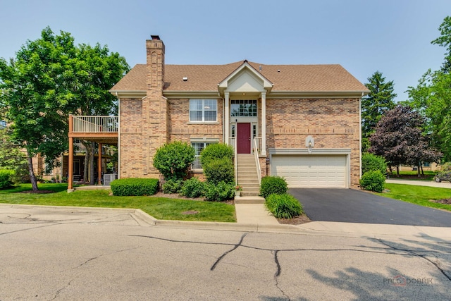 1296 Ashley Ct, Vernon Hills, IL 60061 - view of front of property featuring an attached garage, driveway, brick siding, a chimney, and a front yard