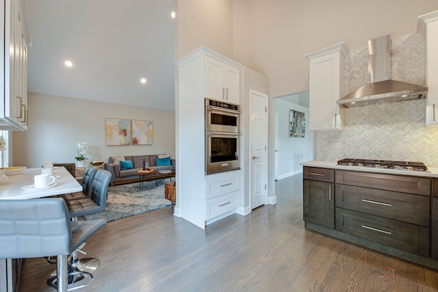 1296 Ashley Ct, Vernon Hills, IL 60061 - kitchen with wall chimney range hood, stainless steel appliances, white cabinetry, tasteful backsplash, and open floor plan