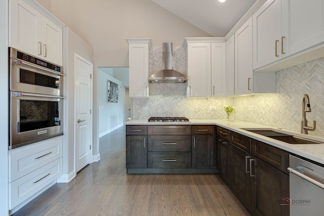 1296 Ashley Ct, Vernon Hills, IL 60061 - kitchen with wall chimney exhaust hood, appliances with stainless steel finishes, white cabinetry, vaulted ceiling, and wood finished floors