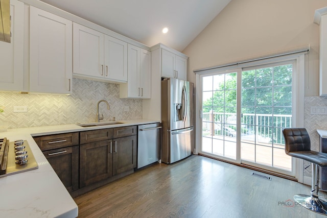 1296 Ashley Ct, Vernon Hills, IL 60061 - kitchen with appliances with stainless steel finishes, vaulted ceiling, light countertops, backsplash, and wood finished floors