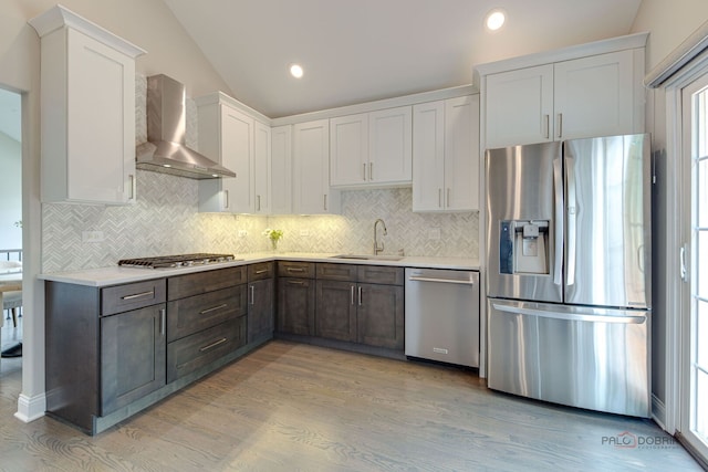1296 Ashley Ct, Vernon Hills, IL 60061 - kitchen featuring appliances with stainless steel finishes, wall chimney exhaust hood, light countertops, light wood finished floors, and backsplash