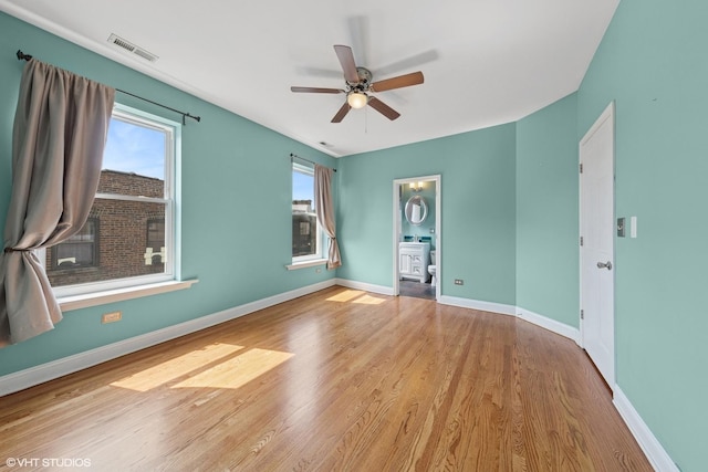 1114 W Pratt Blvd Unit 3S, Chicago, IL 60626 - unfurnished bedroom with multiple windows, wood finished floors, a ceiling fan, and connected bathroom