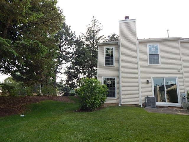 1 N Oltendorf Rd, Streamwood, IL 60107 - back of property featuring a lawn, a chimney, and central air condition unit