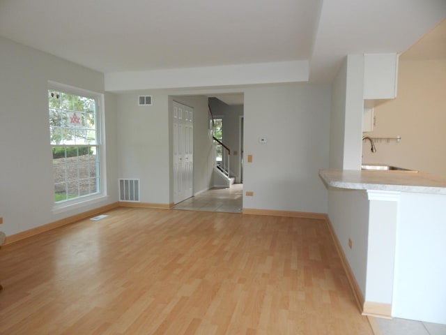 1 N Oltendorf Rd, Streamwood, IL 60107 - unfurnished living room featuring light wood-style flooring, a sink, stairway, and baseboards
