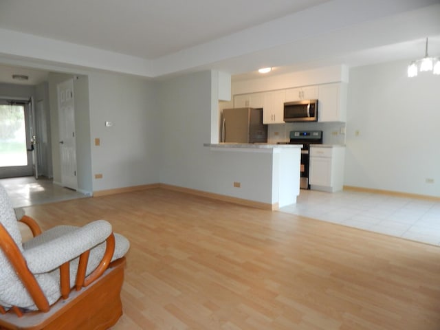 1 N Oltendorf Rd, Streamwood, IL 60107 - living area featuring baseboards, light wood finished floors, and a chandelier
