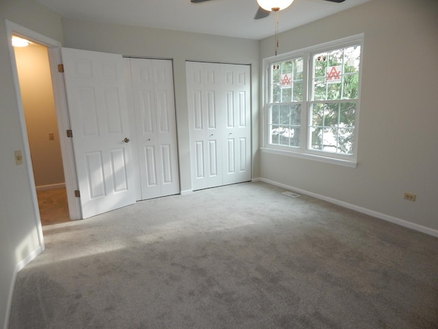1 N Oltendorf Rd, Streamwood, IL 60107 - unfurnished bedroom featuring two closets, carpet floors, baseboards, and a ceiling fan