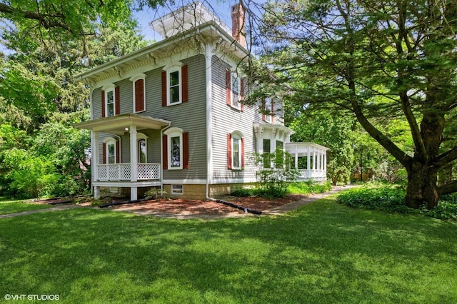 100 E Miller Ave, Hinckley, IL 60520 - italianate house with a chimney, a front yard, a porch, and a sunroom