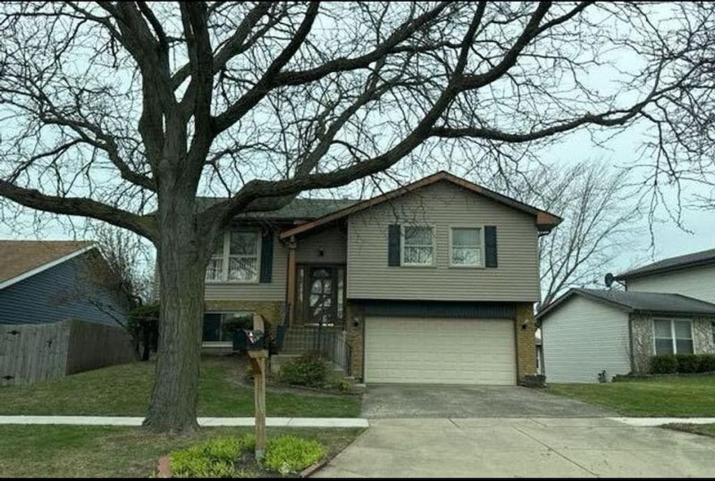 1450 Brookside Dr, Hoffman Estates, IL 60169 - view of front of house featuring an attached garage, driveway, and brick siding
