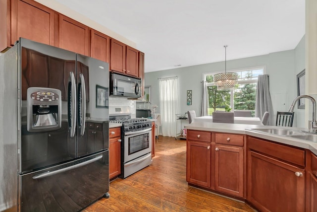 1106 Heron Cir, Joliet, IL 60431 - kitchen featuring black appliances, a sink, dark wood-style flooring, a chandelier, and light countertops