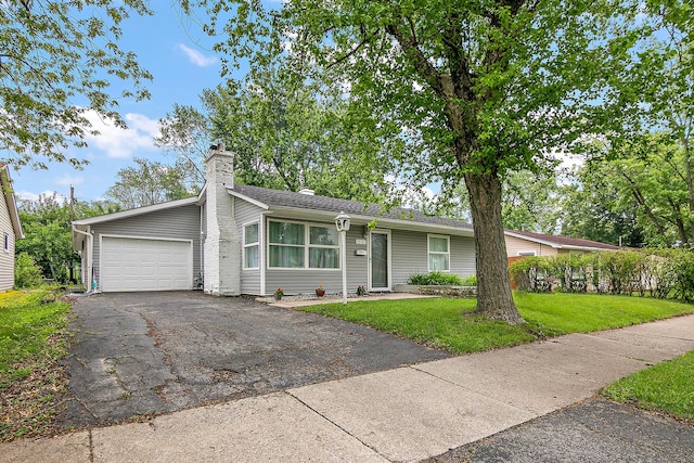 313 Dorsetshire Dr, Steger, IL 60475 - view of front of home with an attached garage, a front lawn, asphalt driveway, and a chimney