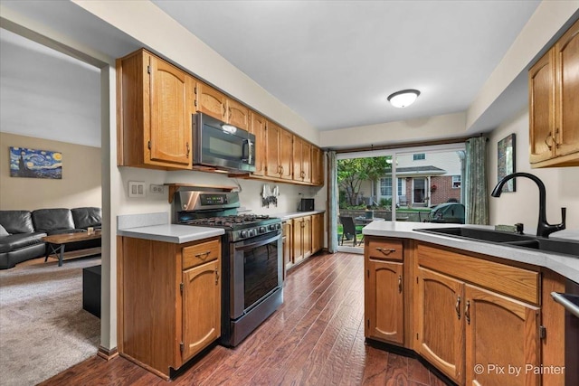 2116 Glasgow Ct, Hanover Park, IL 60133 - kitchen featuring gas range, black microwave, light countertops, and dark wood-type flooring