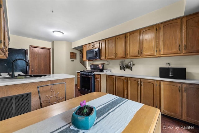 2116 Glasgow Ct, Hanover Park, IL 60133 - kitchen featuring black appliances, brown cabinetry, light countertops, and dark wood-style flooring