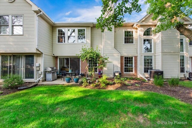 2116 Glasgow Ct, Hanover Park, IL 60133 - rear view of house featuring a patio, a lawn, and brick siding