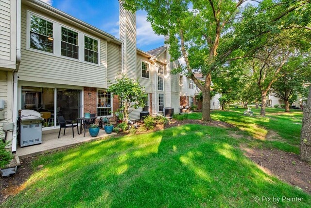 2116 Glasgow Ct, Hanover Park, IL 60133 - rear view of property with a chimney, a yard, a patio area, and brick siding