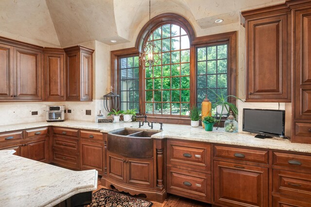 21 Forest Ave, Naperville, IL 60540 - kitchen featuring a sink, vaulted ceiling, tasteful backsplash, brown cabinets, and light stone counters