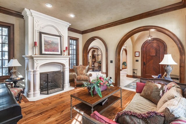 21 Forest Ave, Naperville, IL 60540 - living room featuring arched walkways, wood-type flooring, a fireplace, and ornamental molding