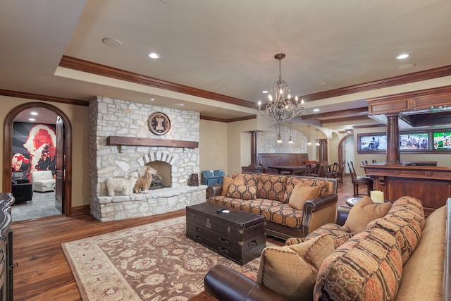 21 Forest Ave, Naperville, IL 60540 - living room with arched walkways, crown molding, a chandelier, a stone fireplace, and wood finished floors