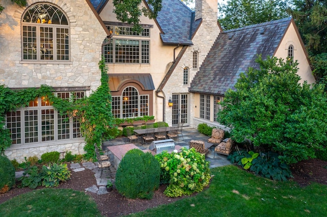 21 Forest Ave, Naperville, IL 60540 - rear view of house featuring stone siding, stucco siding, a patio, and a chimney