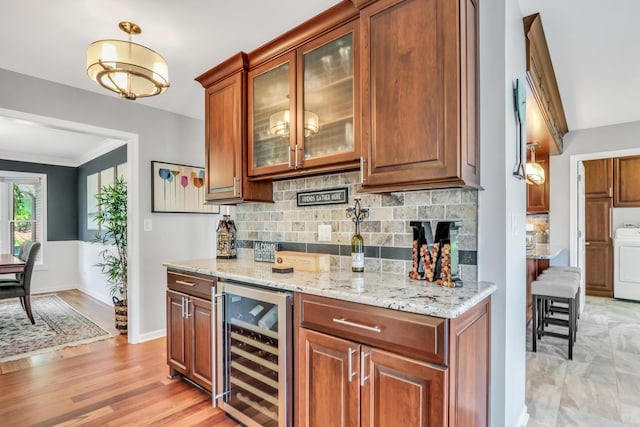 347 Yorkshire Dr, Mundelein, IL 60060 - bar area with wine cooler, washer / dryer, decorative backsplash, crown molding, and hanging light fixtures